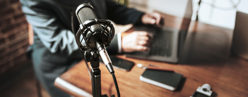 man planning his podcast on computer posted by Podpacer